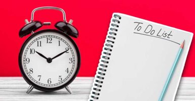 alarm clock and to do list against red background