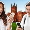 two excited happy students looking at their phones
