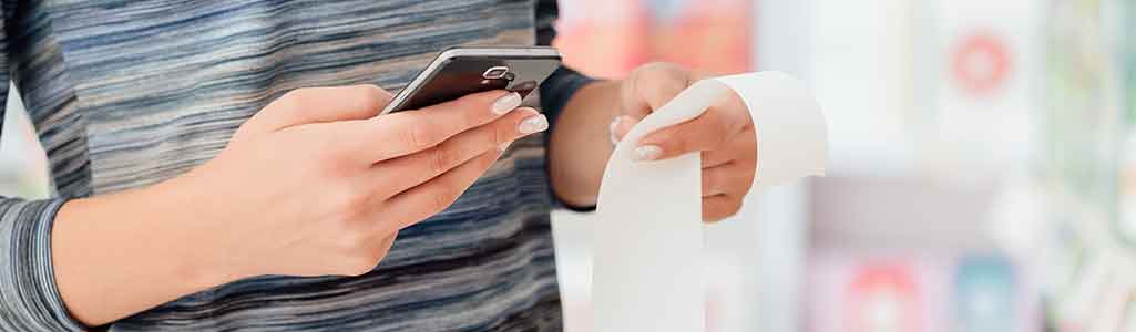 woman holding phone and taking photo of receipt