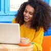 woman on laptop in colourful cafe