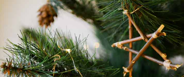 a handmade wooden star hanging on a christmas tree